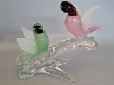 two glass birds that are sitting on top of each other