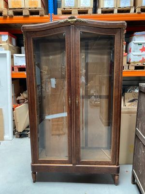 une armoire avec une porte vitrée au milieu d'une pièce
