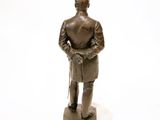 a bronze statue of a man with a hat and a cane