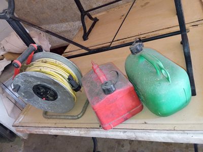 three gas cans and a hose sitting on a table