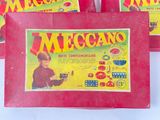 three boxes of meccan toys sitting on top of a white table
