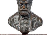 statue représentant le buste d'un homme barbu portant un nœud papillon