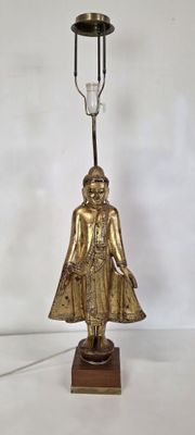 une statue en or représentant une femme tenant une bougie