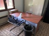 un bureau avec deux chaises et une poubelle devant