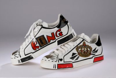 des baskets blanches ornées de logos noirs et rouges sur un fond blanc