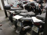 many scooters lined up in a row in a garage