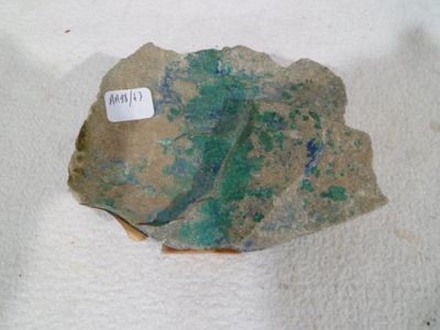 a rock with a tag on it sitting on a white surface