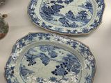 two blue and white plates and a vase on a table