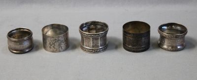 four silver napkins are lined up in a row on a table