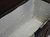 a wooden box with a white cloth inside of it