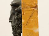 statue of a man with a beard and a marble block in front of him