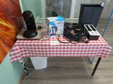 une table recouverte d'une nappe à carreaux, sur laquelle se trouve une cafetière