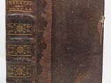 an old book sitting on top of a table next to a white background