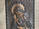 a picture of a metal plaque with a picture of a woman holding a child