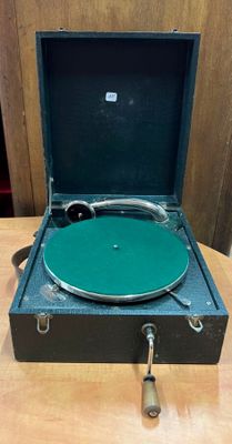 un tourne-disque posé dans une valise sur une table