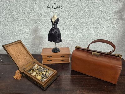 three pieces of jewelry sitting on a table next to a purse