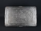 an ornate silver tray with handles and handles on a black background