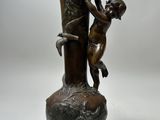 a bronze statue of a boy climbing a tree