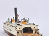 a small model of a boat on a white surface
