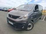 La camionnette grise est garée sur un parking avec d'autres voitures.