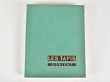 turquoise colored book with black and gold logo on it