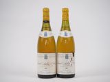 deux bouteilles de vin posées l'une à côté de l'autre sur une surface blanche