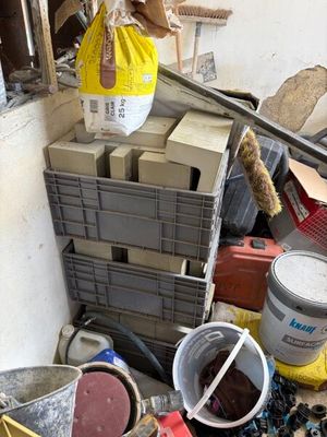 un tas de cartons et de seaux dans un coin de la pièce