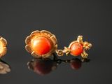 two pairs of gold and coral earrings on a black surface