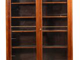 une bibliothèque ancienne en acajou avec des portes vitrées