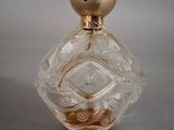 a small glass bottle with a gold lid on a table