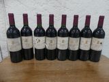 six bouteilles de vin sont alignées sur une table en bois