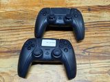 two video game controllers sitting on top of a wooden table