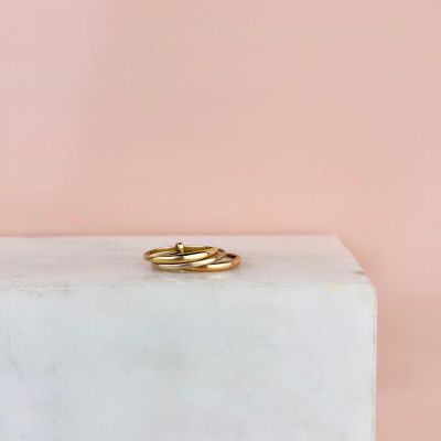 une bague en or posée sur un bloc de marbre blanc