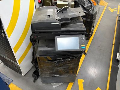 une imprimante posée sur une pile de déchets dans un entrepôt
