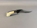 a small knife with a black handle on a table