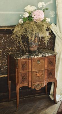 une table sur laquelle se trouve un vase de fleurs