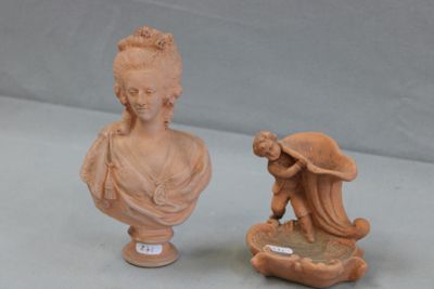 a small statue of a woman with a hat next to a small statue of a woman