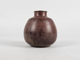 a small brown vase sitting on a white surface