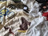 un tas de vêtements sur un lit, avec un chat allongé dessus