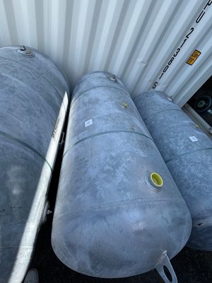 three metal tanks sitting next to each other on the ground