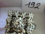 une photo d'une bague en diamant posée sur un tissu blanc