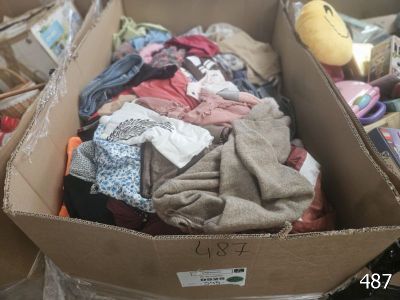 a cardboard box full of clothes and a stuffed animal