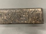 an old silver box with a design on it