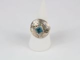 a close up of a silver ring with a blue stone in it