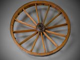 an old wooden wagon wheel on a gray background