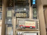 plein de petits camions jouets dans une boîte posée par terre