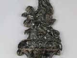 une image représentant une croix accrochée au mur à côté d'une statue d'oiseau