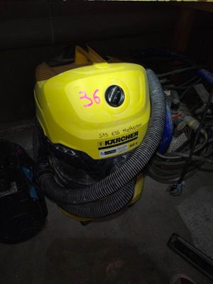 a yellow blower sitting in a garage next to a pile of tools