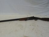 un vieux fusil avec une poignée en bois sur une surface blanche