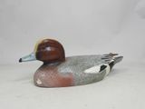 un canard posé sur une surface blanche